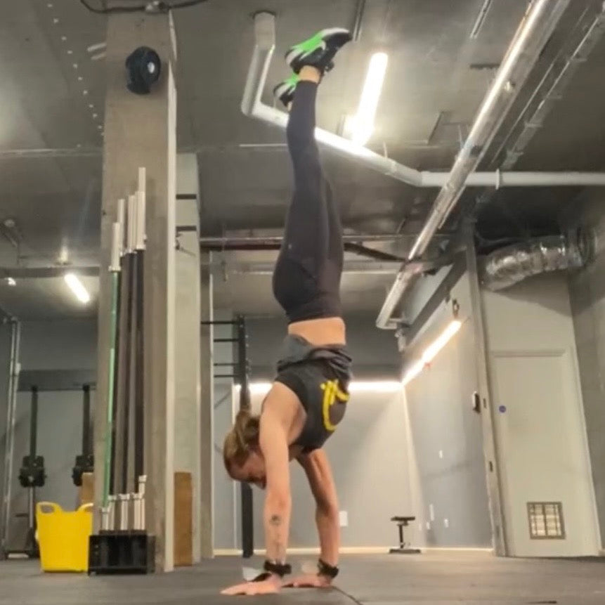 Person doing a handstand in a gym setting
