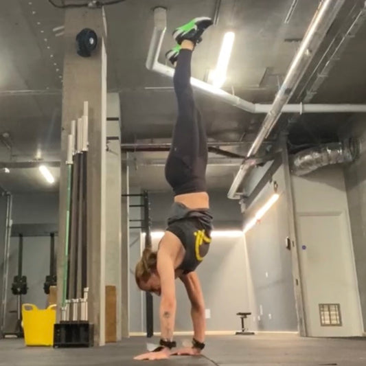 Person doing a handstand in a gym setting